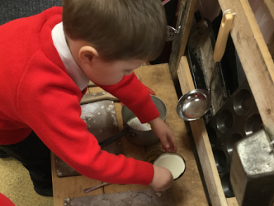 A young pupil is seen experimenting with different cooking utensils.